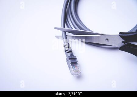 Scissors cut internet cable. Internet shutdown. Cut internet cable. Stock Photo