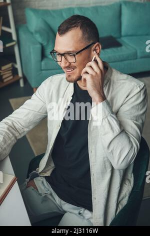 Portrait of a smiling caucasian businessman writing something in notebook during work at office. Internet communication, wireless connection Stock Photo