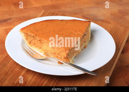 Slice of pumpkin pie on wooden table Stock Photo