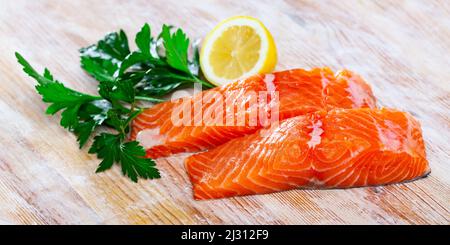 Raw salmon fillet with lemon and greens before cooking Stock Photo