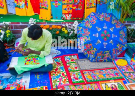 Blurred image of Kolkata, West Bengal, India. Young Bengali artist painting Pattachitra or Patachitra - traditional, cloth-based scroll painting. For Stock Photo