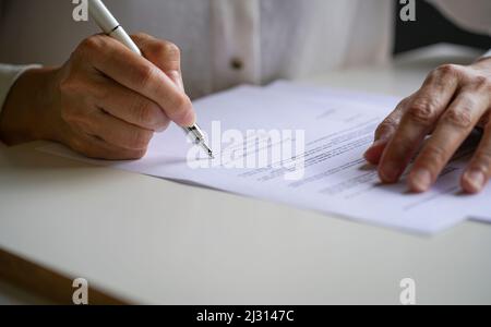 Businesswoman putting her signature on a contract agreement. Close up view with copy space. Stock Photo
