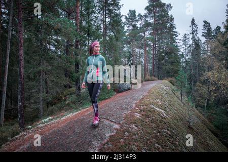 Woman hiking in the forest of Tiveden National Park in Sweden Stock Photo