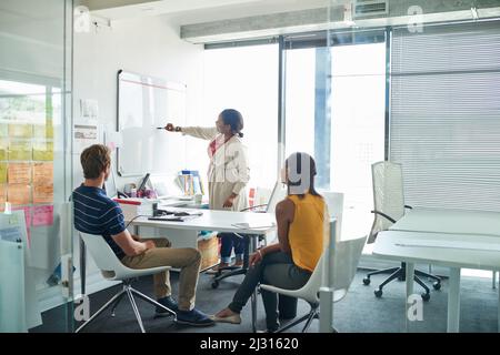 Sharing ideas as a team. Shot of three colleagues having a meeting in an office. Stock Photo