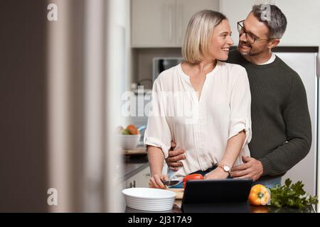 I know that whatever youre making will be delicious. Shot of a mature couple cooking together at home. Stock Photo