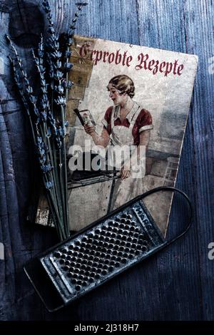 old cookbook with lavender and grater on rustic wooden table Stock Photo