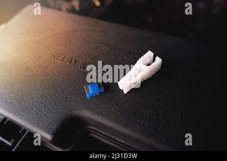 The spare fuse and the fuse clip tool on the car fuse box, automotive electronics part concept Stock Photo