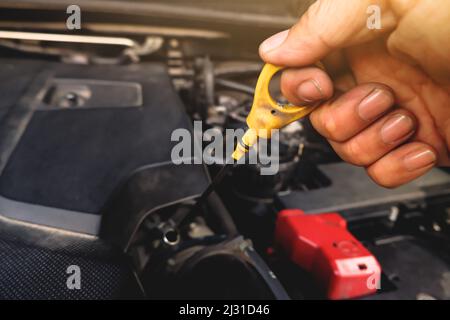 Mechanic hand was pulling oil dipstick to lube level checking of engine car Stock Photo