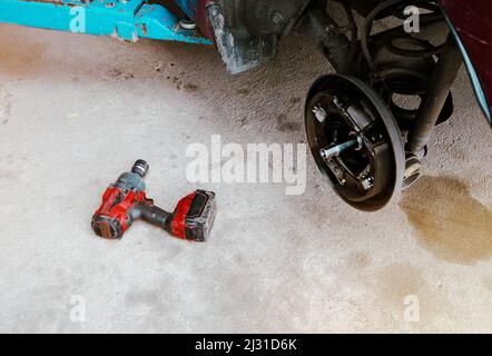 Cordless electric impact wrench on the floor in the auto repair garage Stock Photo