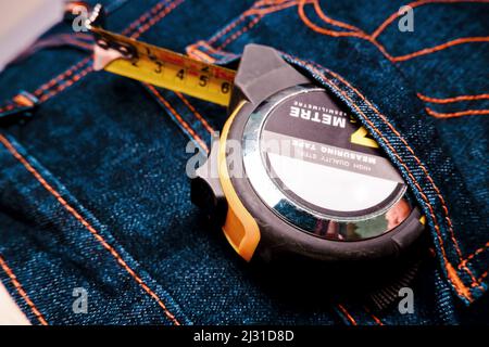 Measuring tape on the back denim pocket of mechanic man Stock Photo