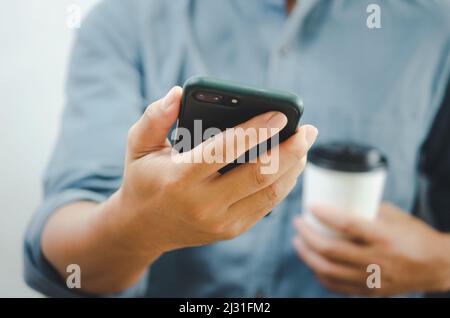 hand man holding smartphone and coffee paper cup. Stock Photo