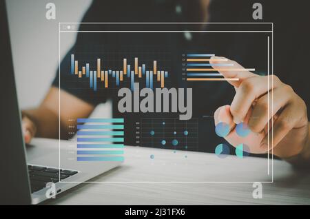 man hand using laptop to working technology.Hand toucing virtual screen graph and chart data analysis and big data business concept. Stock Photo
