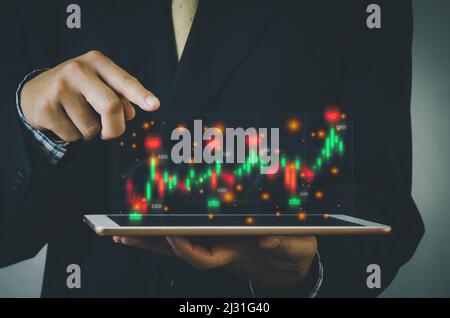 Finance and business investment concept. Stock and crypto investment funds.Businessman analyzing or trading Forex graphs of financial data candlestick Stock Photo