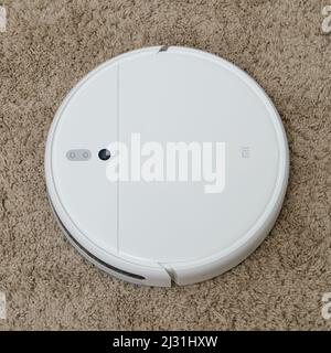 White robot cleaner Xiaomi Mi Vacuum-Mop on a fleecy carpet, close-up - Moscow, Russia, March 05, 2022 Stock Photo