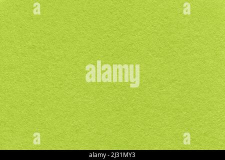 Texture of bright green and olive colors paper background, macro. Structure of dense lime craft cardboard. Felt backdrop closeup. Stock Photo