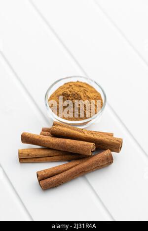 Dry cinnamon sticks and cinnamon powder on a white table. Cinnamon spice. Stock Photo