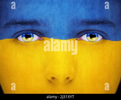 Male face painted with the flag of Ukraine. Reflection Flag of Ukraine in eyes. Stock Photo