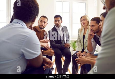 Diverse group of serious business people discussing something during meeting in office Stock Photo