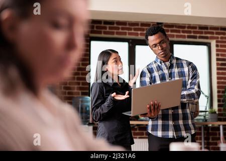 Software developers analyzing received encrypted files by scanning them for malware. Cyber security agency employees using laptop to monitoring internet bandwidth and database used storage. Stock Photo