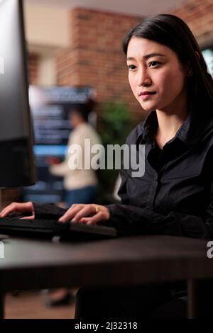 Application developer encrypting cloud storage database by updating network algorithm. Asian system administrator upgrading firewall system in order to maintain security stability. Stock Photo