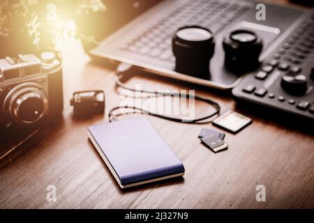 Closeup external hard drive on wooden desktop. Working with external hard drive. Stock Photo