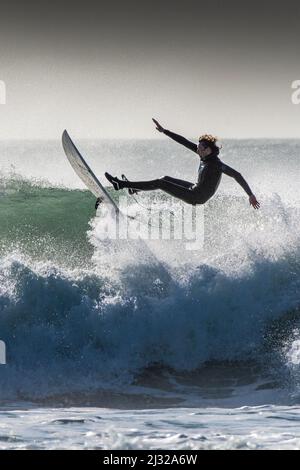 A surfer losing balance and wiping out at Fistral in Newquay in Cornwall in the UK. Stock Photo