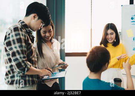 Teamwork,brainstorming concept.Young asian creative managers team working with new startup project in modern office Stock Photo