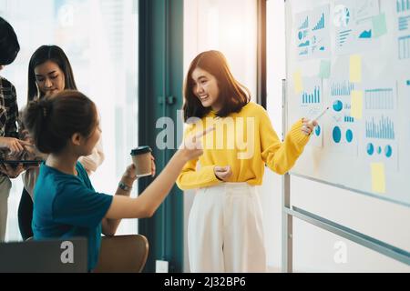 Young Asian Female Financial Analyst Giving Presentation To Board Members.. Stock Photo