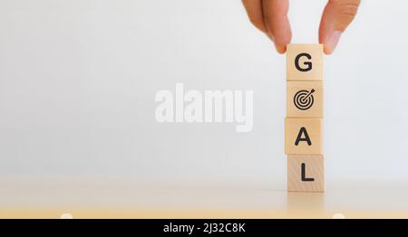 Business targeting and winning and success concepts. Goal word written on wooden cubes on the table with beautiful white background, copy space. The i Stock Photo