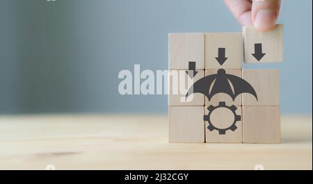 Risk Management Concept. Business Strategy and Development. Businessman put the wood cube with risk management symbols on grey background with copy sp Stock Photo