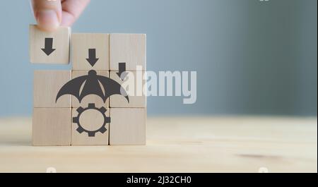 Risk Management Concept. Business Strategy and Development. Businessman put the wood cube with risk management symbols on grey background with copy sp Stock Photo