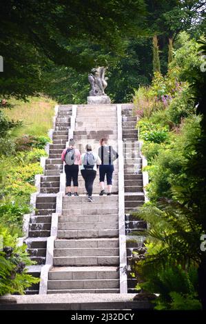 Three Women Walking up Steps to Neptune's Statue & Water Cascade at Holker Hall & Gardens, Lake District, Cumbria, England, UK. Stock Photo