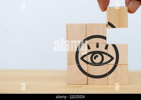 Company vision concept. Businessman put the wooden cubes with 'VISION'  symbol on beautiful white background and copy space. Banner for symbols of vis Stock Photo