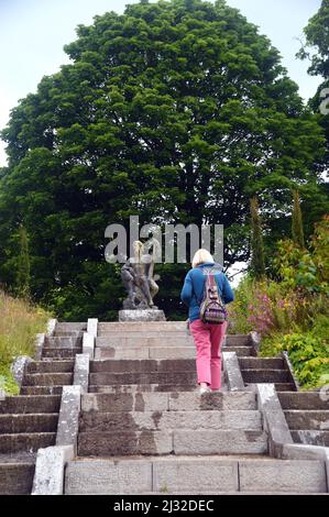 Woman Walking up Steps to Neptune's Statue & Water Cascade at Holker Hall & Gardens, Lake District, Cumbria, England, UK. Stock Photo