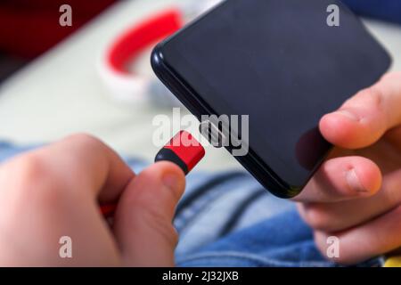 Magnetic phone charger in teenager's hands. Close-up. Stock Photo