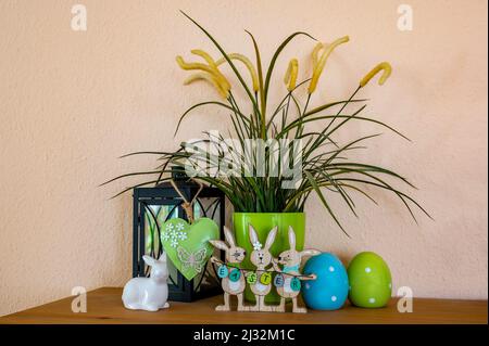 Flowerpot, wooden Easter bunnies with the text Easter on the Easter eggs and other decoration. Stock Photo