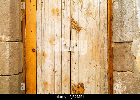 Rusty padlock locking old wooden door with a chain, Tavira, Portugal Stock Photo