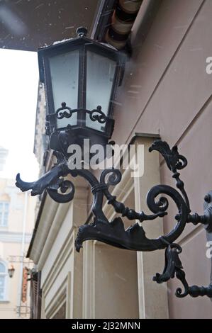 Ancient lantern with frosted glass on an old house in Lviv on a sunny day Stock Photo