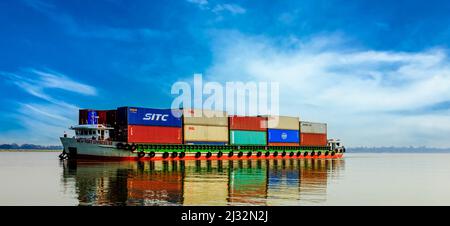 A very colorful container ship going down the Mekong River from Cambodia to Vietnam. Stock Photo