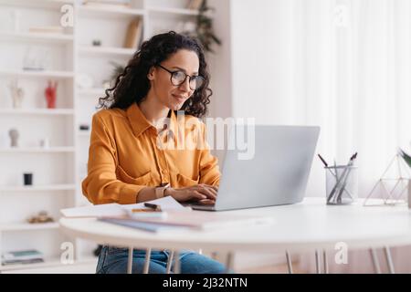 Middle Eastern Lady Using Laptop Working Online Sitting In Office Stock Photo