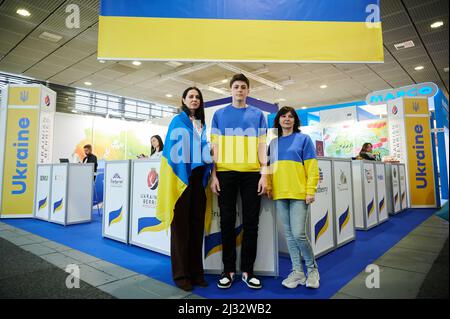 Berlin, Germany. 05th Apr, 2022. Natalia Netudykhata (l-r), her 17-year-old son Kyrylo and Tatiana Nikolaeva stand at the Fruit Logitica fair with Ukrainian flags and sweaters. They are employees of the Artberry company and their plantation is in Ukraine. They represent their husbands at the fair, who do not leave their country because of the war. Natalia, Kyrylo and Tatiana return to Kiev after the fair. Credit: Annette Riedl/dpa/Alamy Live News Stock Photo