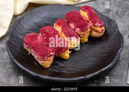 Raspberry eclair cake on dark background. World cuisine delicacies. close up Stock Photo