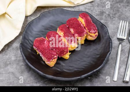 Raspberry eclair cake on dark background. World cuisine delicacies. close up Stock Photo