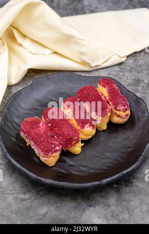 Raspberry eclair cake on dark background. World cuisine delicacies. close up Stock Photo