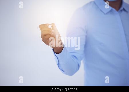Young, rich, stupid. Easy prey for cupid. Shot of an unrecognizable businessman making notes on a glass screen against a bright background. Stock Photo