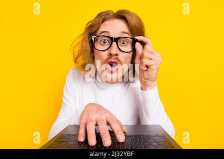 Photo of funny impressed guy dressed white shirt arm glasses writing modern device isolated yellow color background Stock Photo