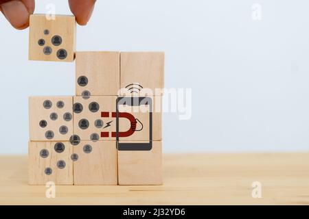 Attracting online customer and lead generation concept. Digital inbound marketing, customer retention strategy.Hand hold wooden cube with the icon big Stock Photo
