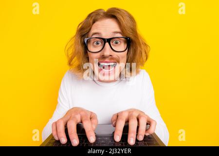 Photo of positive funky guy wear white shirt spectacles chatting modern gadget isolated yellow color background Stock Photo