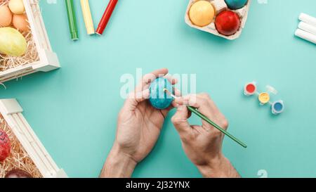 hand painting colorful easter eggs on blue background  Stock Photo