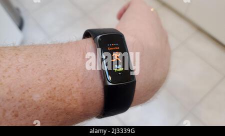 Person s wrist with Fitbit Charge 5 fitness tracker showing